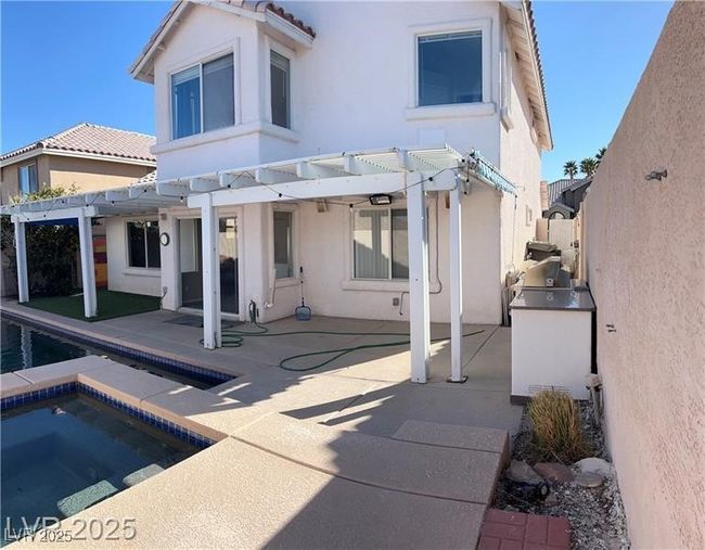 Rear view of house with a pergola and stucco siding | Image 12