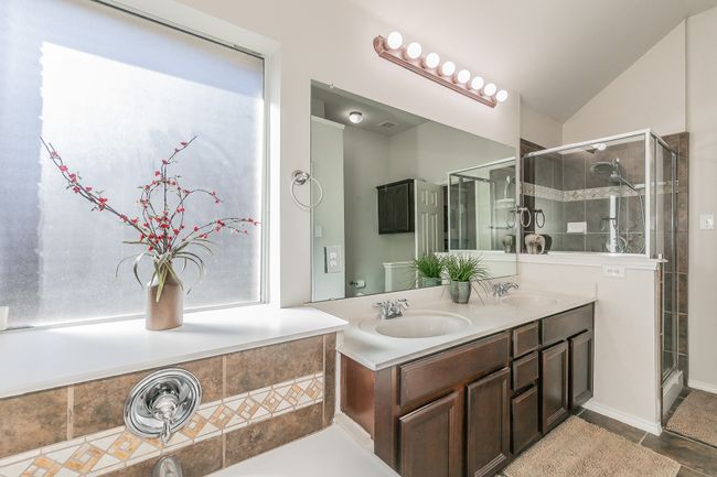 Full bathroom with double vanity, a stall shower, lofted ceiling, and a sink | Image 24