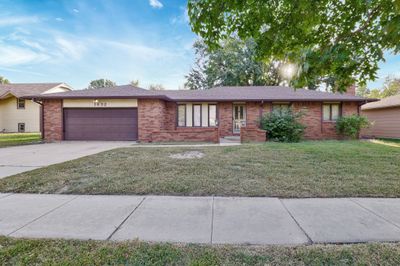 Ranch-style home with a front yard and a garage | Image 1