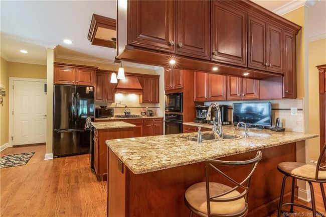 The heart of the home...this kitchen features warm cherry cabinetry, granite counters and more. | Image 5
