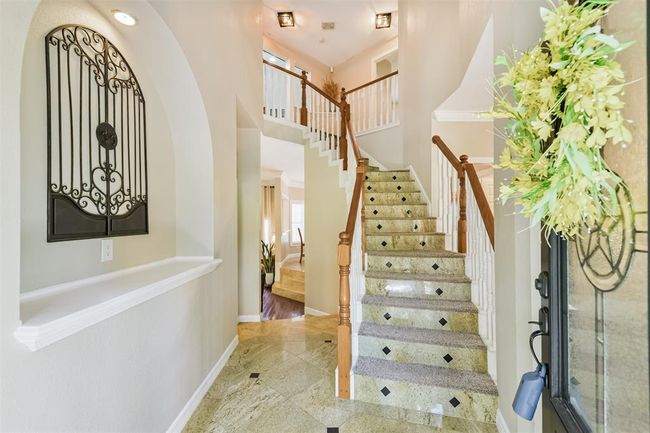 Welcoming and elegant entryway with stunning staircase. | Image 4