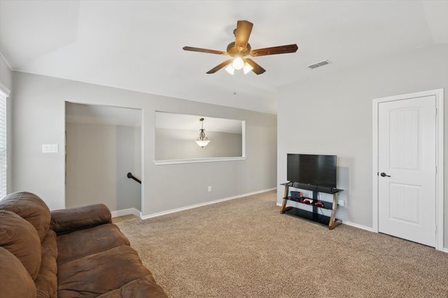 Living area featuring carpet, visible vents, baseboards, and a ceiling fan | Image 22
