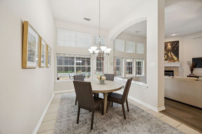 Tucked at the back of the home, the casual dining area is surrounded by windows and offers direct patio access—perfect for enjoying morning coffee or easy indoor-outdoor flow. | Image 14