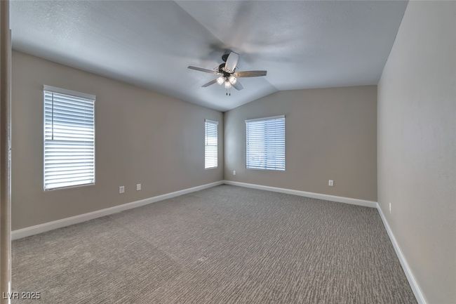 Unfurnished room featuring ceiling fan, carpet flooring, and vaulted ceiling | Image 18
