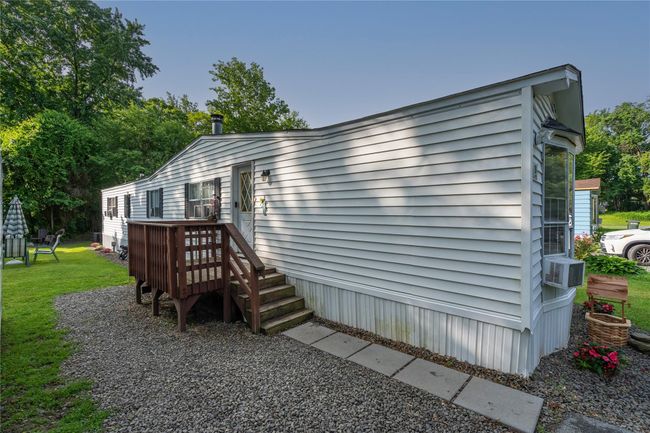 View of home's exterior with a lawn, a wooden deck, and cooling unit | Image 16