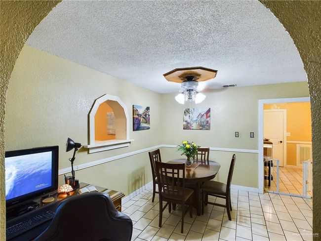 Dining space featuring light tile floors, a textured ceiling, and ceiling fan | Image 8