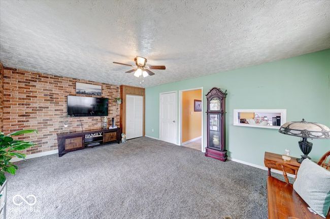 a small view window from the kitchen to the den, a closet, and the door to the basement | Image 22