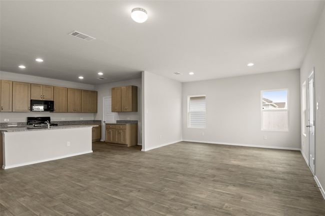 Kitchen with recessed lighting, black microwave, visible vents, dark wood finished floors, and stove | Image 8