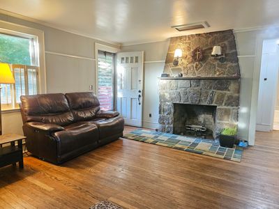 Stone fireplace with hardwood floors, a comfortable room all year round! Open the front door for extra sunshine and breezes, or cozy up next to the fireplace on chilly nights. | Image 2