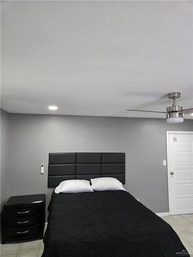Bedroom with light tile patterned floors, a ceiling fan, and baseboards | Image 8