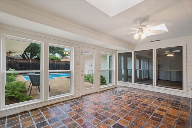 Unfurnished sunroom featuring skylights, tile floors, and a ceiling fan | Image 26