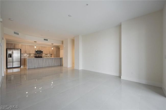 Unfurnished living room featuring baseboards, visible vents, and light tile patterned floors | Image 5