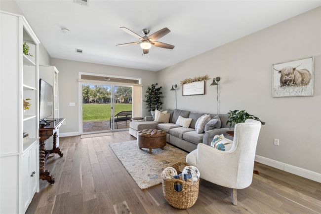 Living area featuring baseboards, visible vents, wood finished floors, and a ceiling fan | Image 13