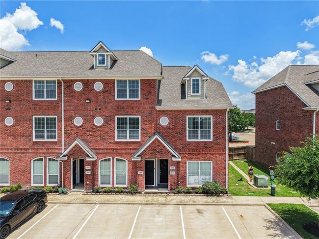 View of front of home featuring brick siding, uncovered parking, and a shingled roof | Image 22