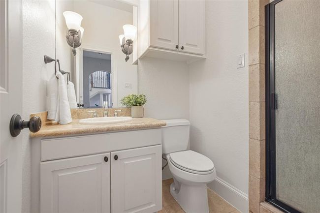 Conveniently accessible from the study, this well-appointed full bathroom features elegant fixtures and modern conveniences. | Image 24