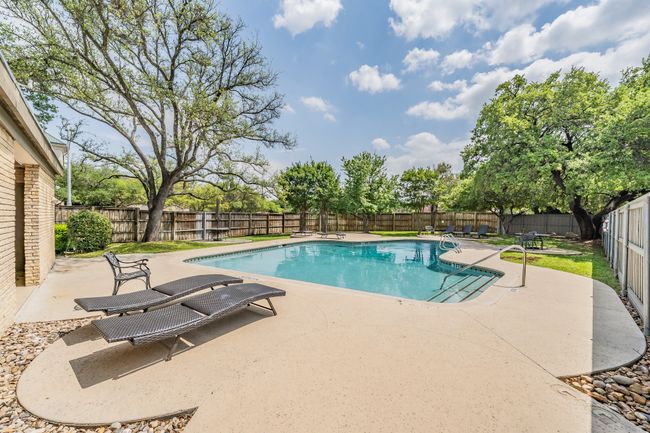 View of swimming pool featuring a fenced backyard, a fenced in pool, and a patio | Image 26