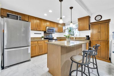 Open design kitchen with island bar for extra seating and counter space. | Image 1