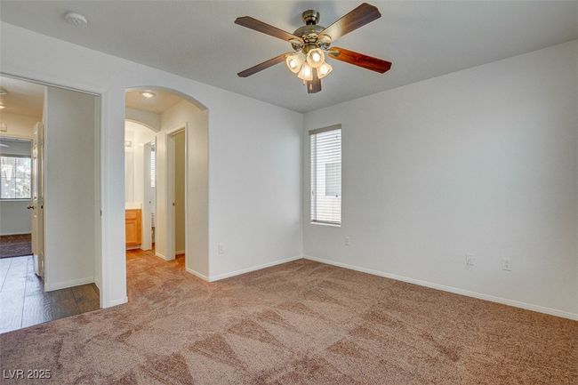 Spare room with carpet floors, ceiling fan, baseboards, and arched walkways | Image 15
