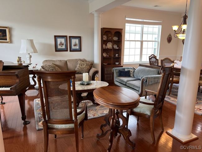 Dining area featuring a notable chandelier, wood-type flooring, and ornate columns | Image 7