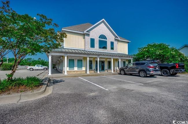 View of front of home with uncovered parking, a standing seam roof, covered porch, and metal roof | Image 4