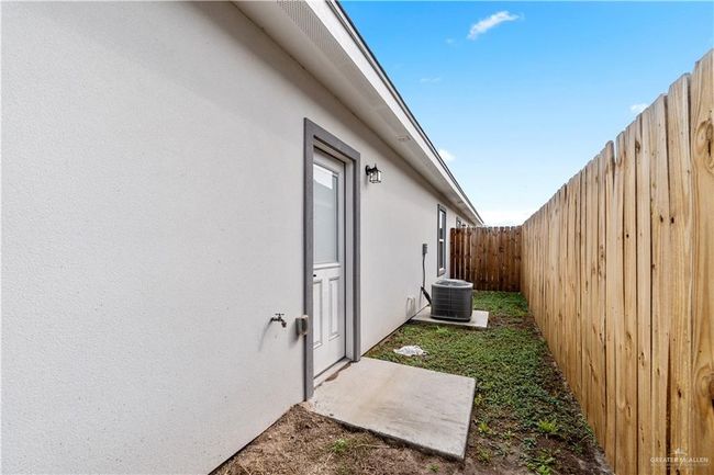 View of property exterior with stucco siding and a fenced backyard | Image 16