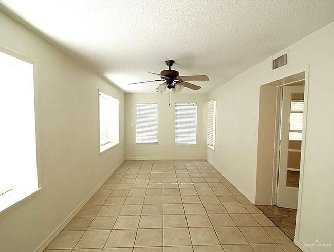 Spare room with a ceiling fan, light tile patterned floors, healthy amount of natural light, and a textured ceiling | Image 8