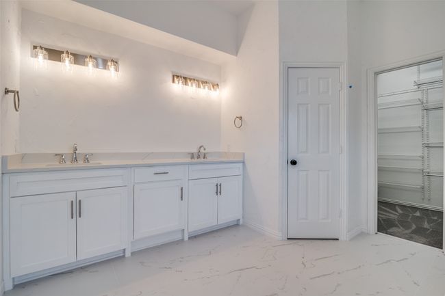 Bathroom featuring marble look tile flooring, double vanity, and a spacious closet | Image 16