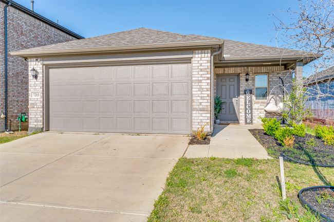 View of front of property with roof with shingles, a garage, concrete driveway, and brick siding | Image 24