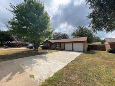 Ranch-style house featuring a garage and a front yard | Image 2