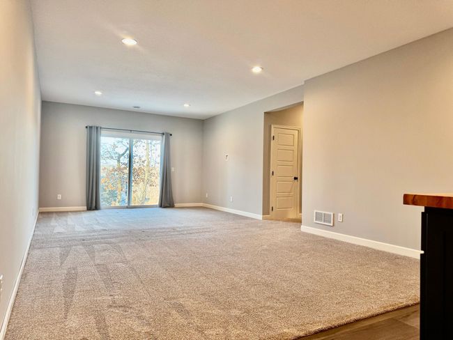 The large family room features a walkout slider patio door. | Image 15