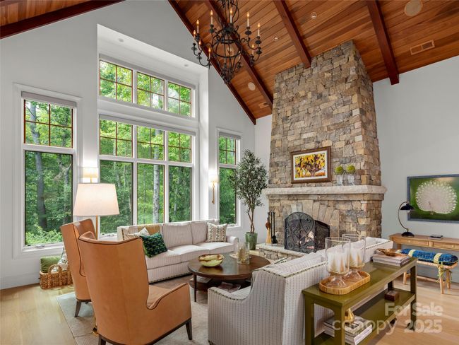 Main living room with floor-to-ceiling stone natural gas log fireplace. | Image 7