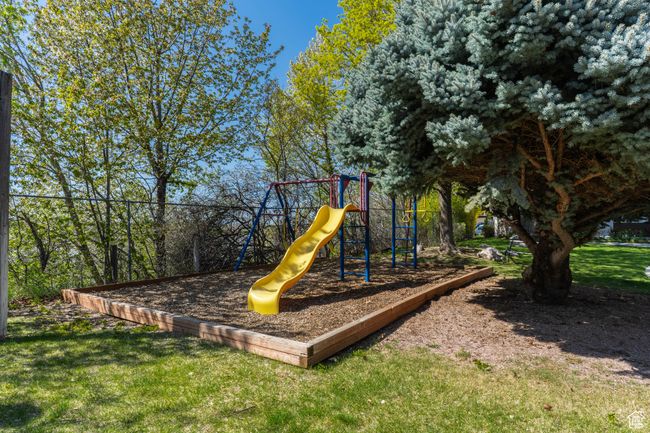 Community playground featuring a lawn and fence | Image 34