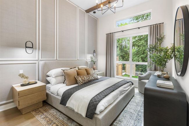 Bedroom featuring a chandelier, light wood-style flooring, and a decorative wall | Image 4