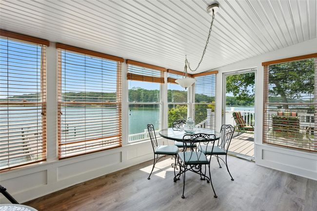 Sunroom featuring healthy amount of natural light, a water view, wood finished floors, and vaulted ceiling | Image 35