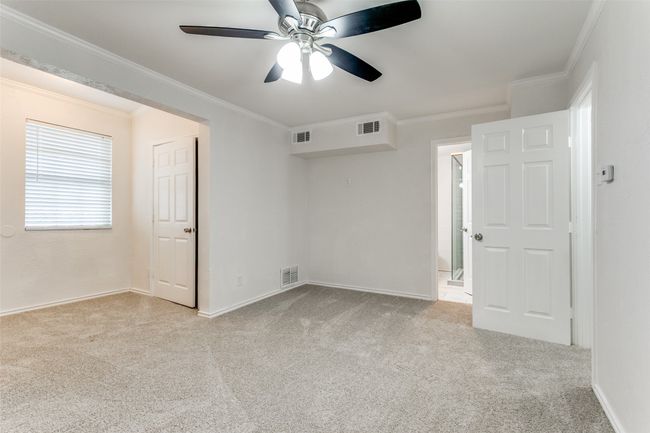 Empty room featuring carpet, visible vents, a ceiling fan, and ornamental molding | Image 19