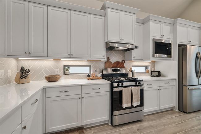 White cabinets, stylish backsplash and remarkable quartz counterstops. | Image 12
