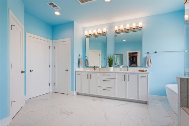 Bathroom with a freestanding tub, double vanity, marble finish floors, baseboards, and recessed lighting | Image 25