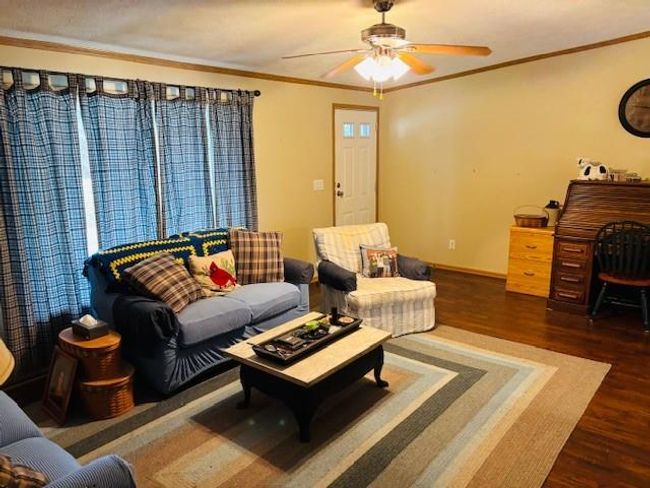 Living area featuring crown molding, ceiling fan, wood finished floors, and baseboards | Image 7