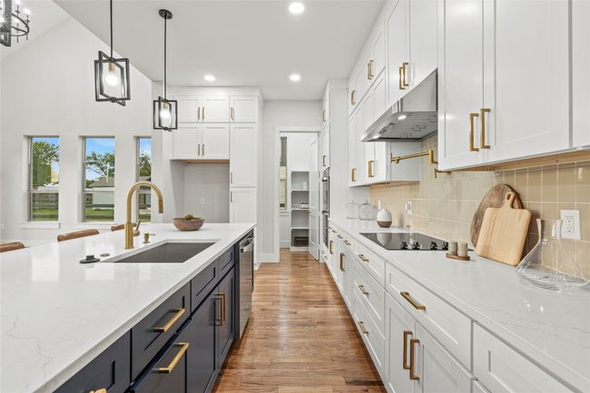 Kitchen with range hood, white cabinetry, appliances with stainless steel finishes, light wood-style floors, and recessed lighting | Image 9