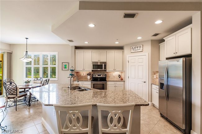 GREAT VIEW OF THE KITCHEN & BREAKFAST AREA! NOTICE THE PLANTATION SHUTTERS IN THE MAIN AREAS OF THE HOME! | Image 14