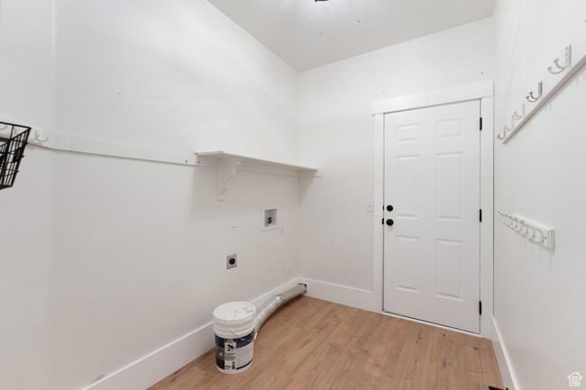 Laundry area featuring hookup for a washing machine, light wood-style flooring, and electric dryer hookup | Image 24