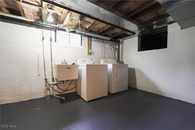 Washroom featuring washing machine and clothes dryer, a sink, and laundry area | Image 32