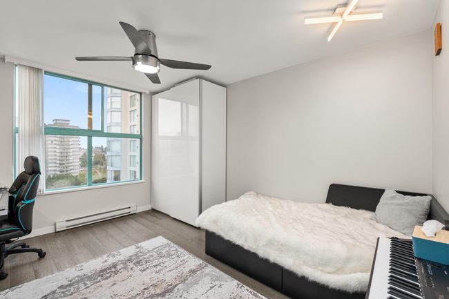 Bedroom featuring baseboards, baseboard heating, wood finished floors, and ceiling fan | Image 25