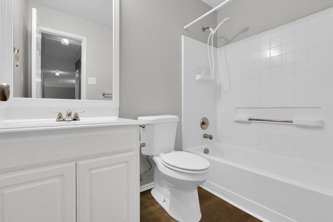 Bathroom with toilet, vanity, bathing tub / shower combination, and wood finished floors | Image 26