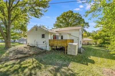 Rear view of property featuring a wooden deck, a lawn, and central AC | Image 3