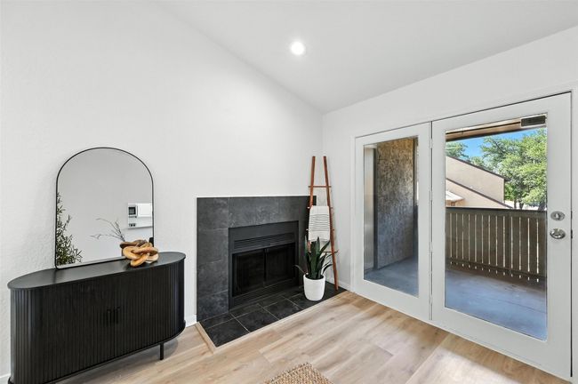 Living area with wood finished floors, a tile fireplace, recessed lighting, and high vaulted ceiling | Image 11