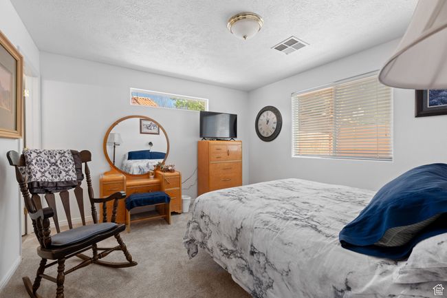 Bedroom featuring a textured ceiling, visible vents, baseboards, and carpet floors | Image 12