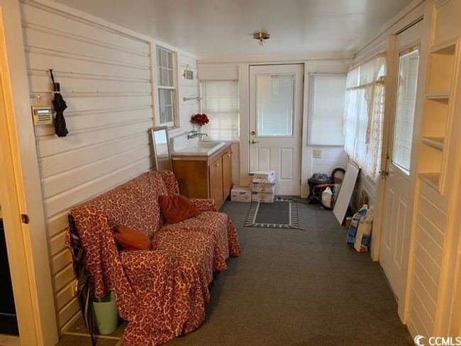 Sunroom with carpet floors and a sink | Image 8