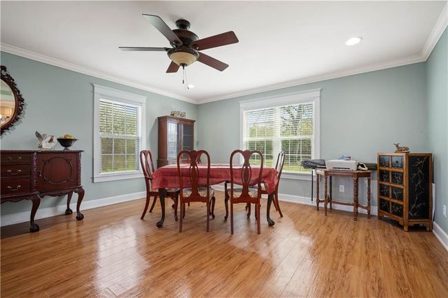 Dining space featuring baseboards, crown molding, and light wood-style floors | Image 13