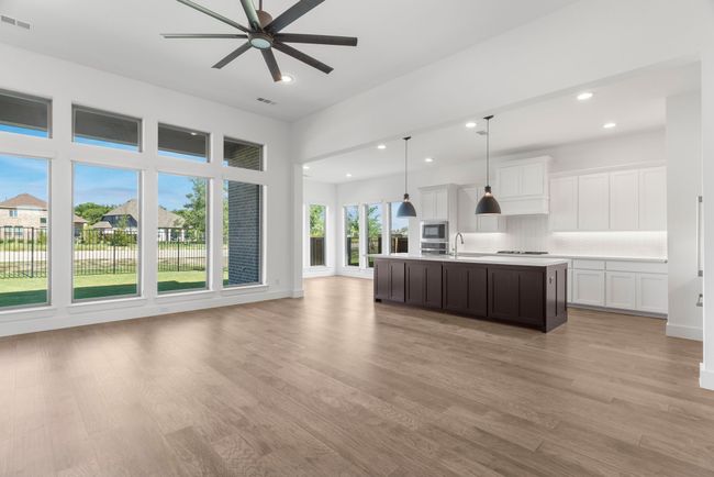 Kitchen featuring a sink, light countertops, open floor plan, ceiling fan, and backsplash | Image 21